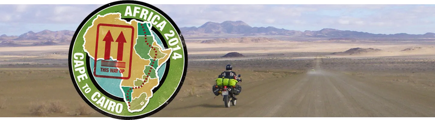A rider on a gravel road, mountains on the horizon